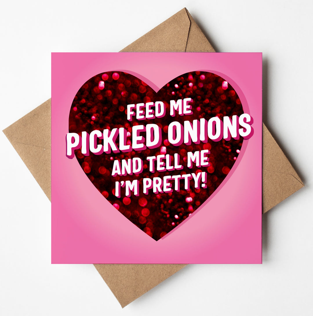 A gorgeous candy-colored Valentine's Day card with a heart and the text "Feed me pickled onions and tell me I'm pretty!" rests on a brown envelope.